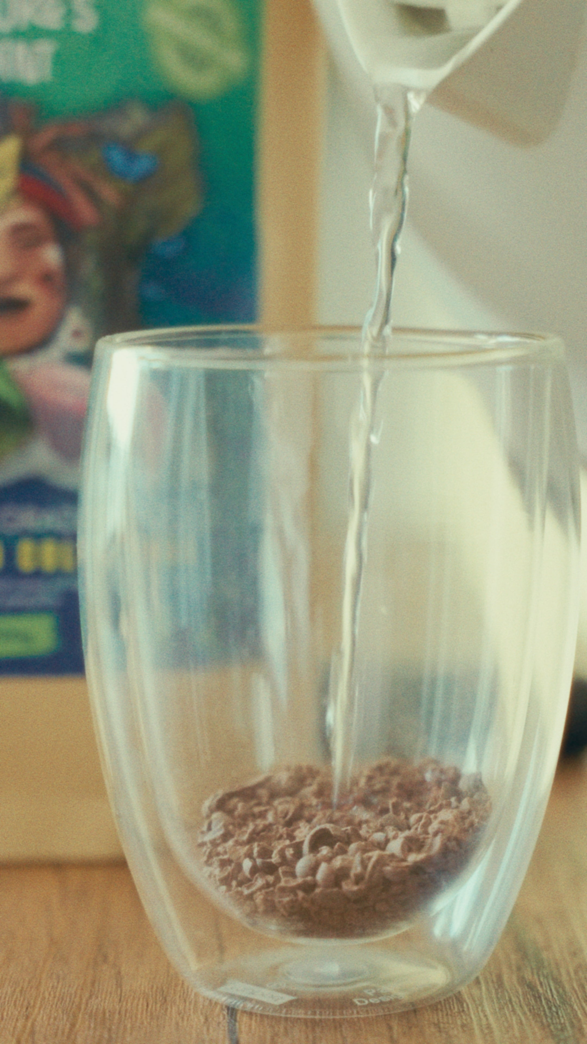 hot water pouring into clear glass cup with cacao.